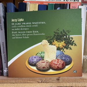 ksiażka na której okładce znajduje się talerz z wielkanocnymi jajami i barankiem